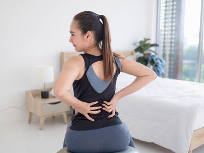 woman with back pain from a mattress that is sagging and too soft